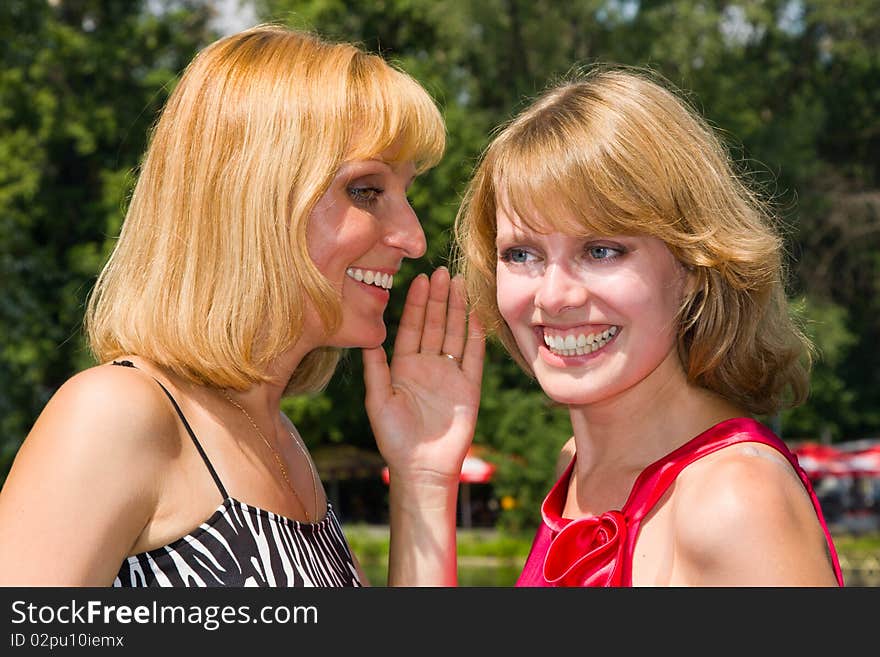 Two Gossiping Girls Outside.