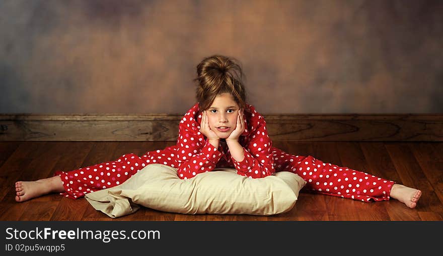 A pretty preteen with her pillow doing splits in poka-dot pajamas. A pretty preteen with her pillow doing splits in poka-dot pajamas.