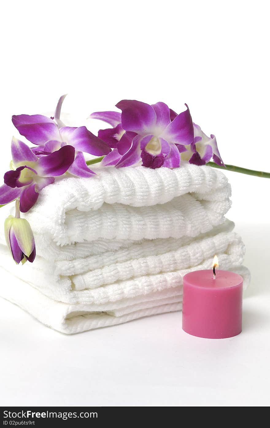 A beautiful orchid, towel and candles. A beautiful orchid, towel and candles