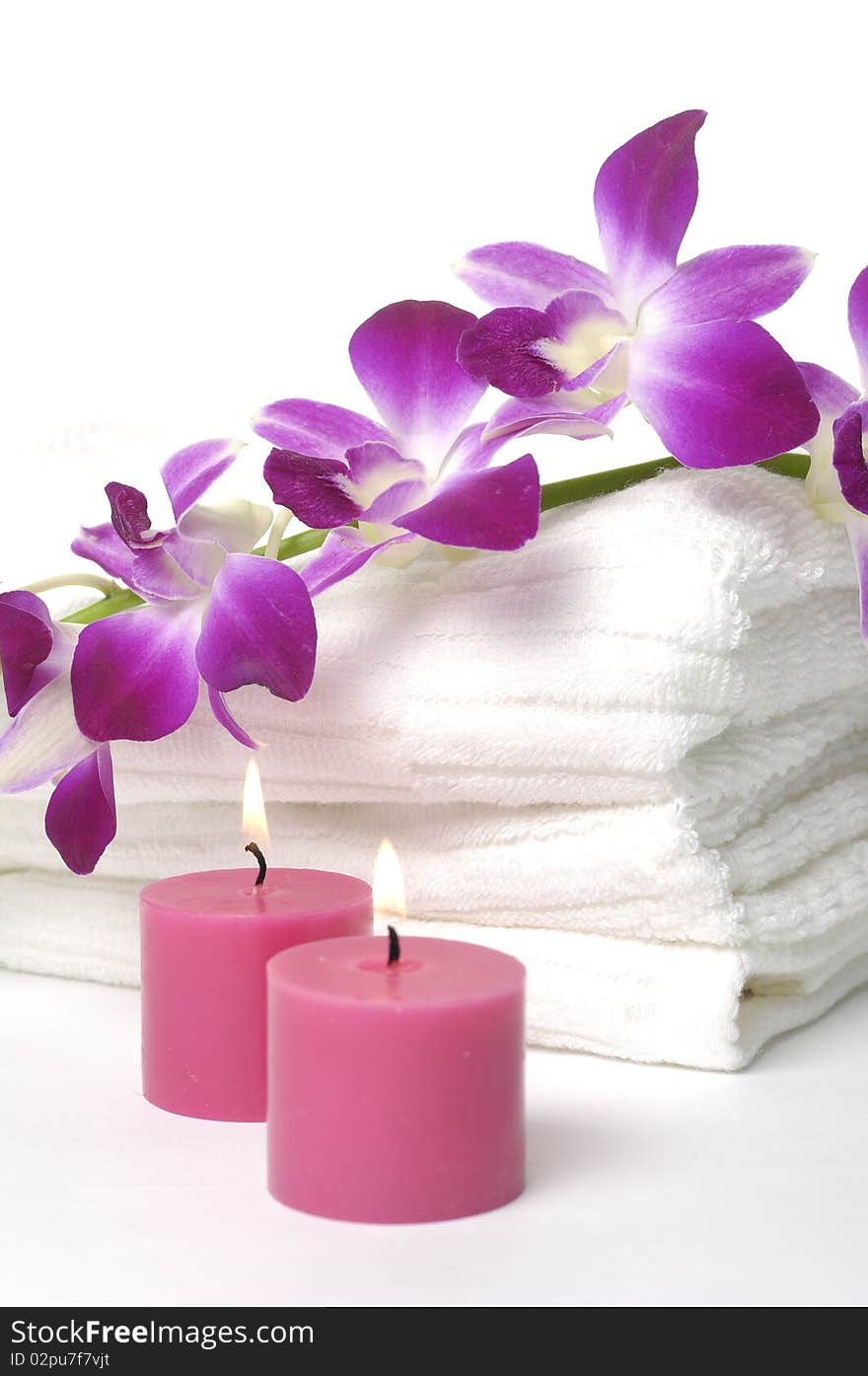 A beautiful orchid, towel and candles. A beautiful orchid, towel and candles