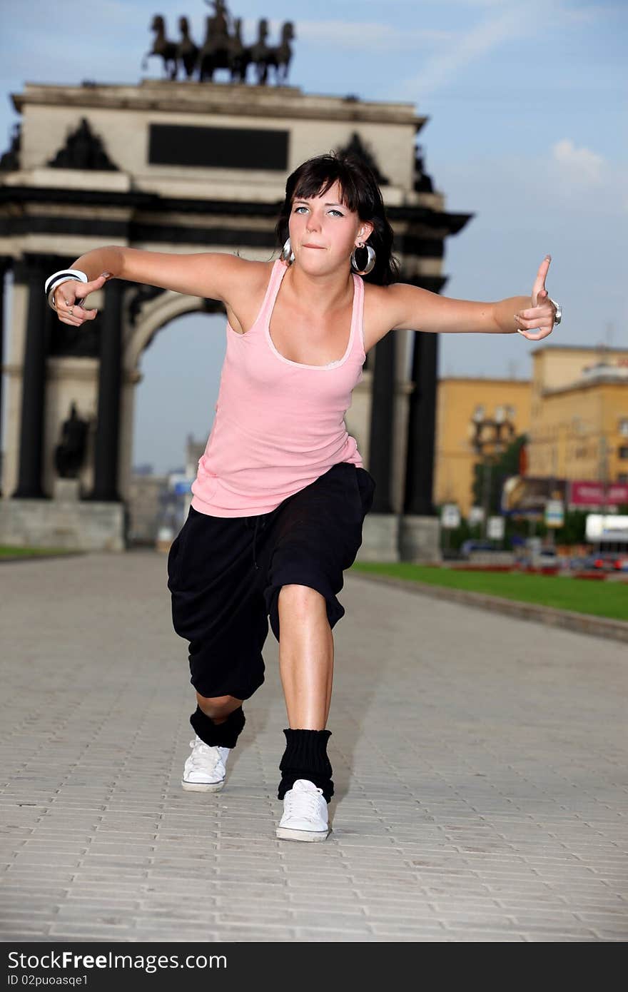 Woman modern dancer in city against classic arch