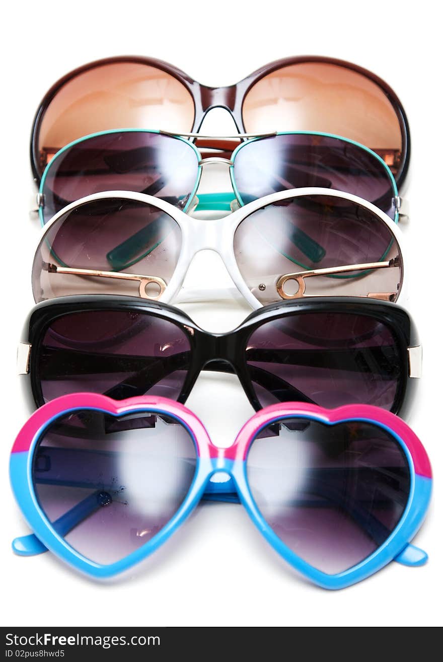 Much sunglasseses put in row on white background