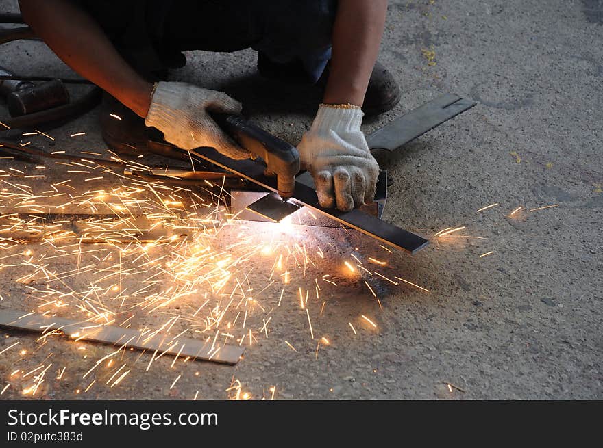 A worker is cutting metal sheet. A worker is cutting metal sheet.