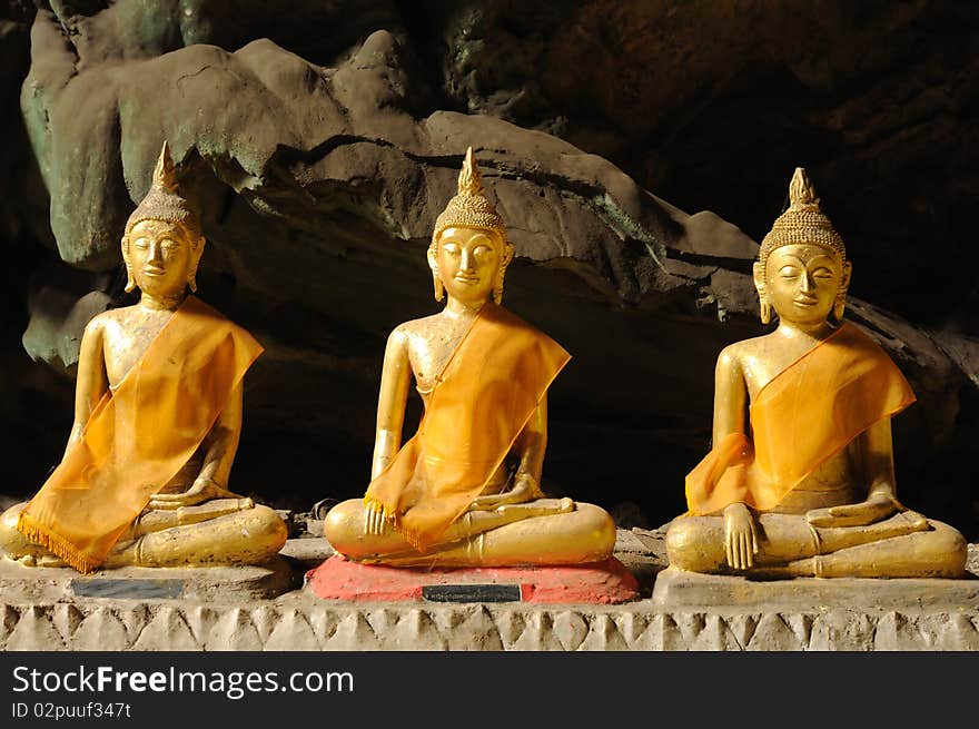 Three Buddha statue in cave.