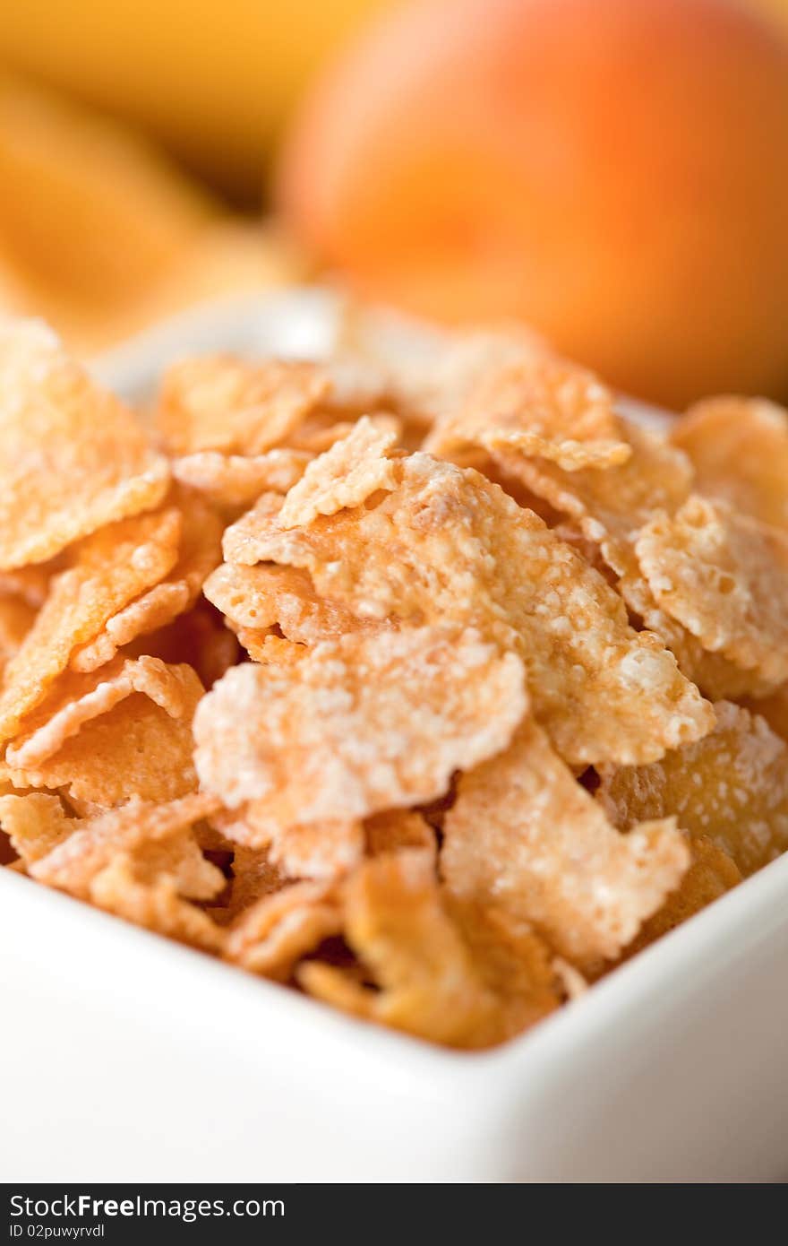 Cornflakes in closeup in a white bowl. Cornflakes in closeup in a white bowl