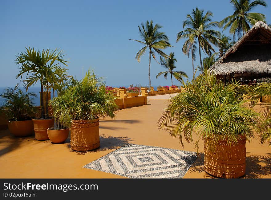 Bungalow from wattled straw against palm trees and the sky. Bungalow from wattled straw against palm trees and the sky