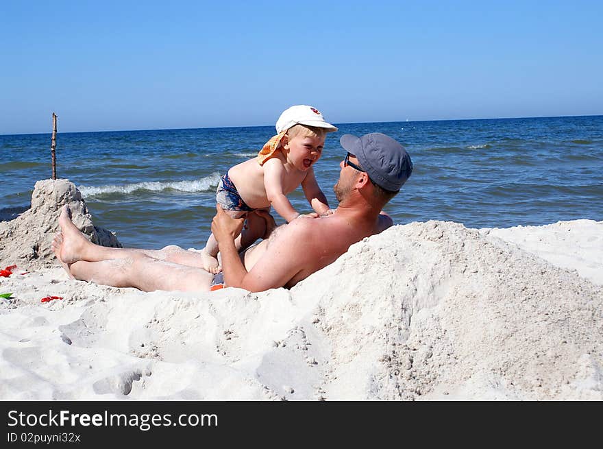 The father and son on the beach playing together