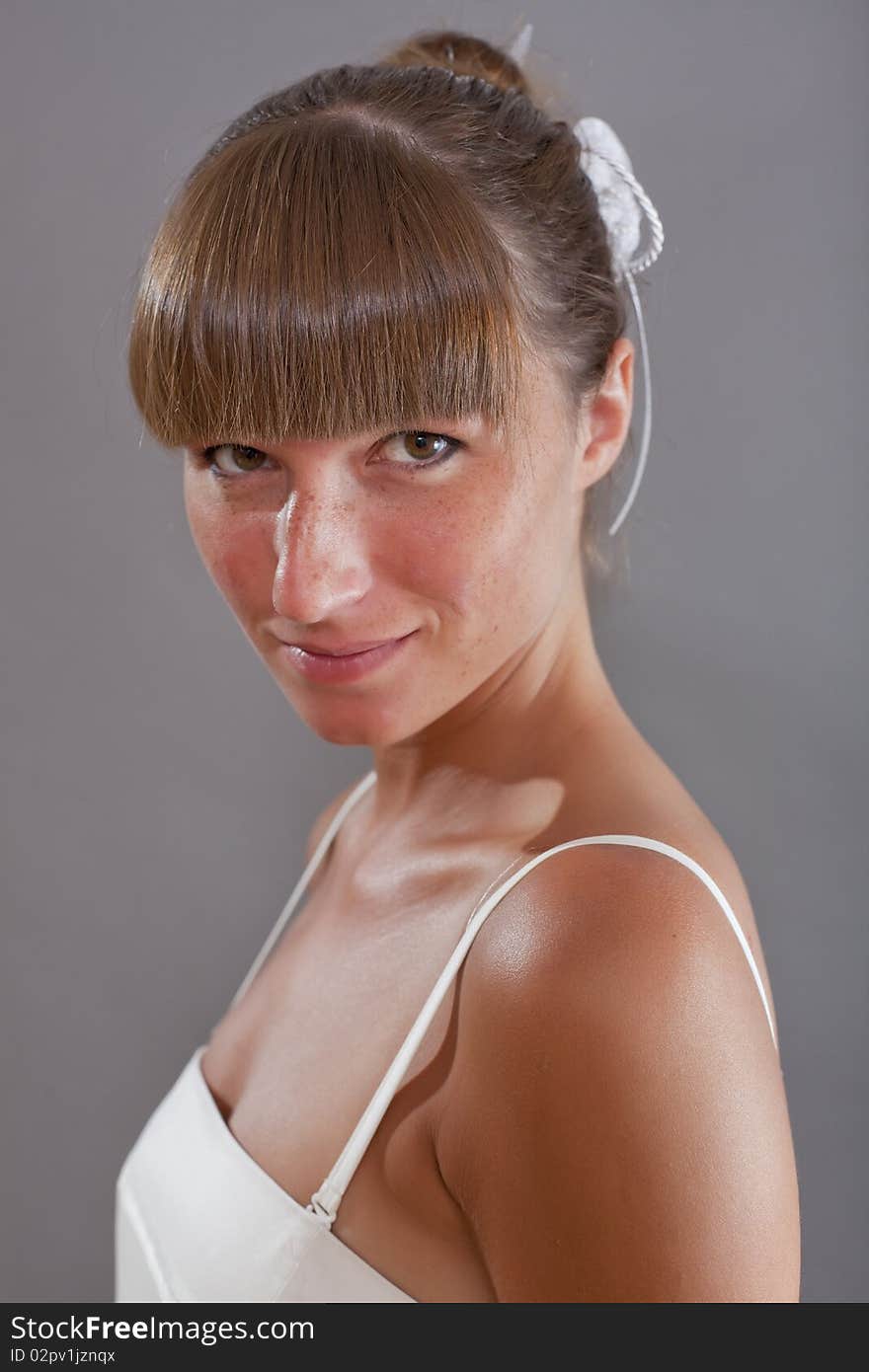 Portrait of woman in white dress over grey background. Portrait of woman in white dress over grey background