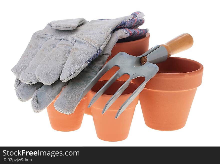 Steel rake on white background near to ceramic pots. Steel rake on white background near to ceramic pots.