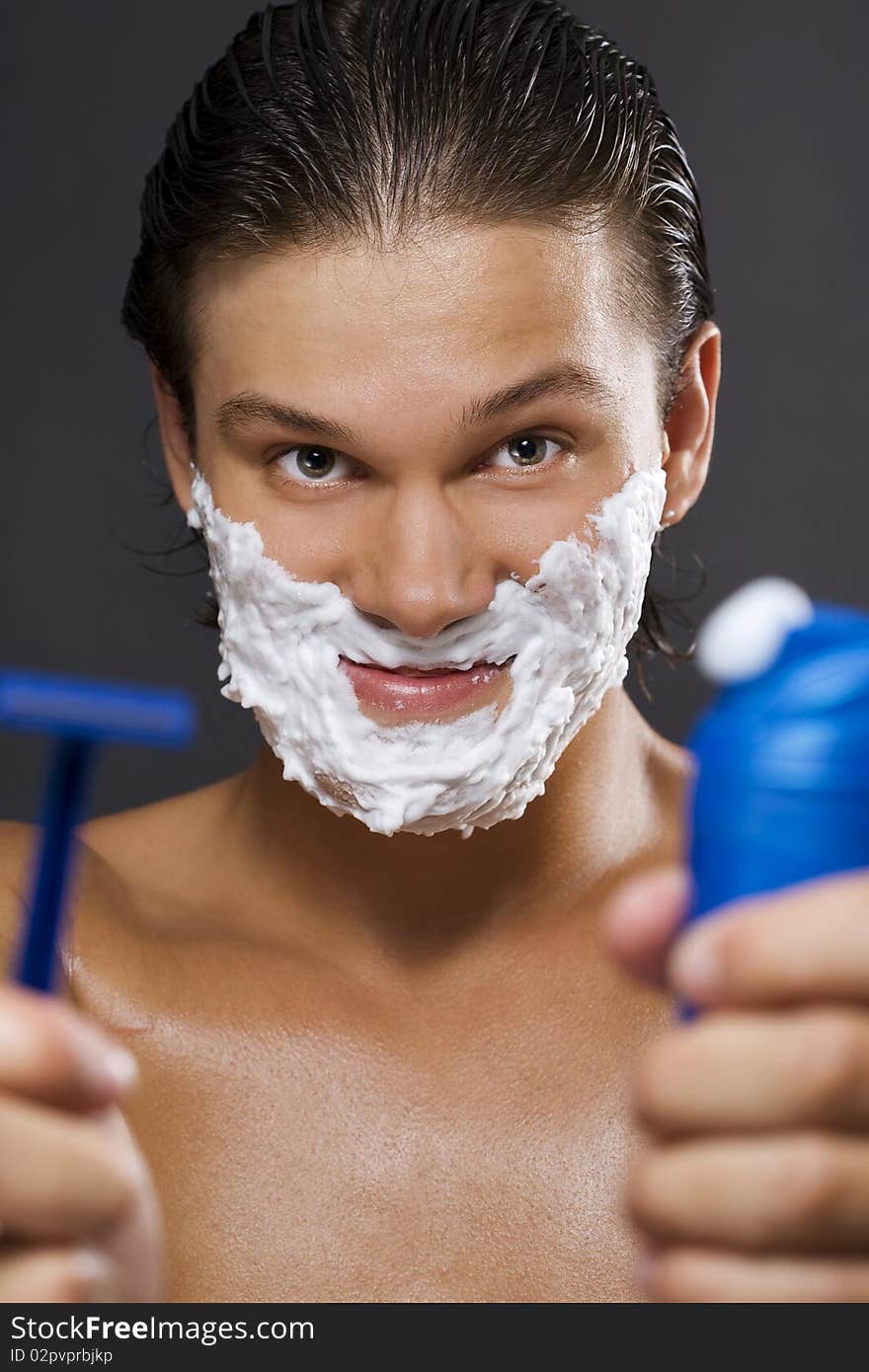 handsome young man shaving. handsome young man shaving