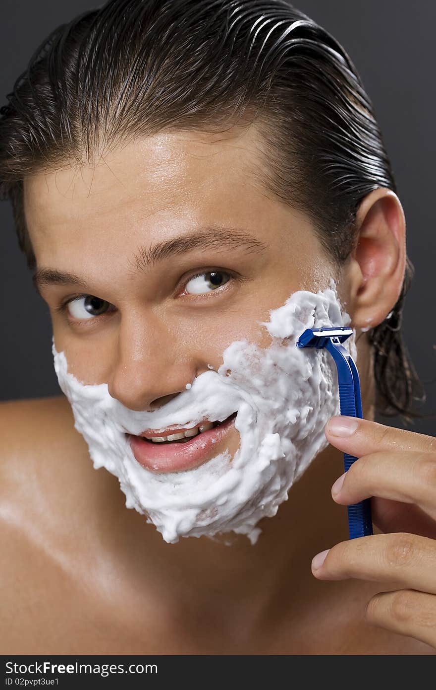 handsome young man shaving. handsome young man shaving