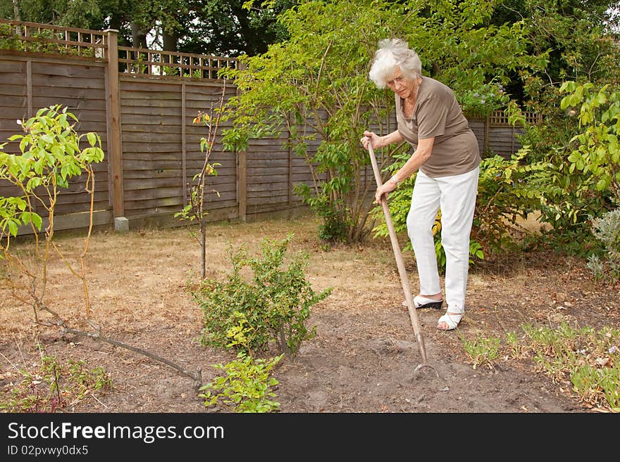 Senior lady gardener doing a little maintenance work. Senior lady gardener doing a little maintenance work