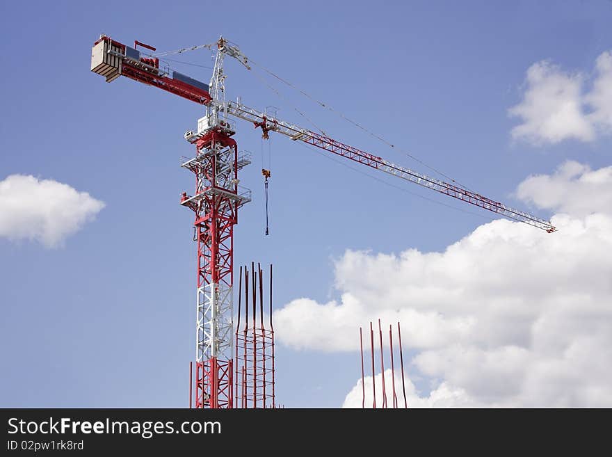 The upper part of the construction crane on a background of blue sky