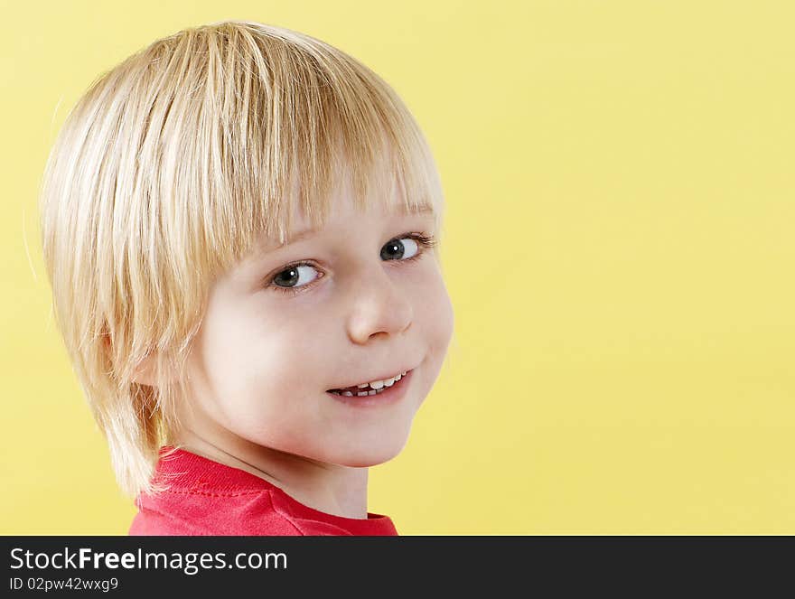 Portrait boy of preschool age on a yellow background