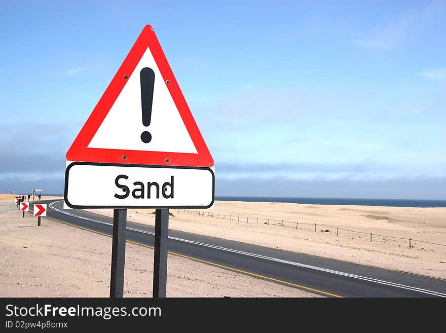 Sign warning drivers of blowing sand in the desert of Namibia. Sign warning drivers of blowing sand in the desert of Namibia