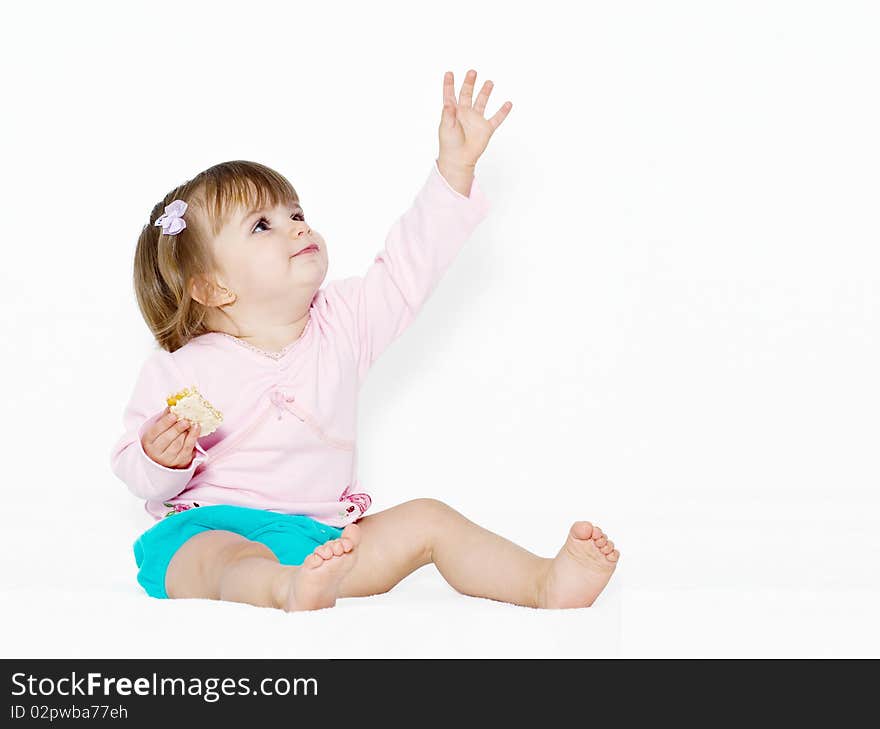 The little girl with the stretched hand on a light background