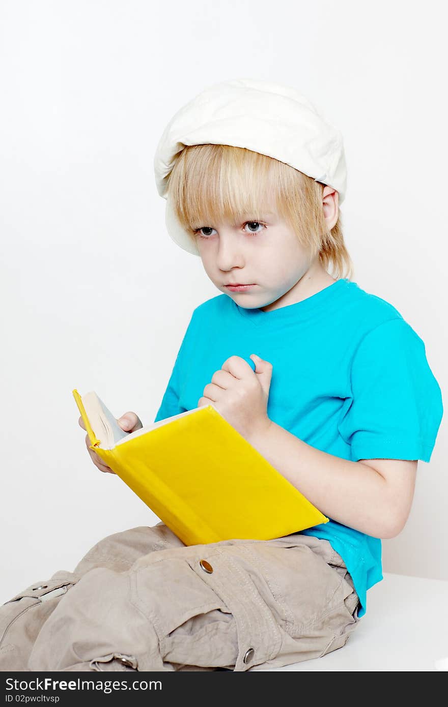 The boy of preschool age with book on a light background