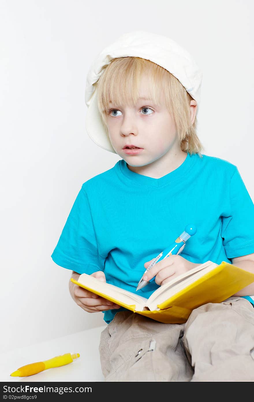 The boy of preschool age with book on a light background