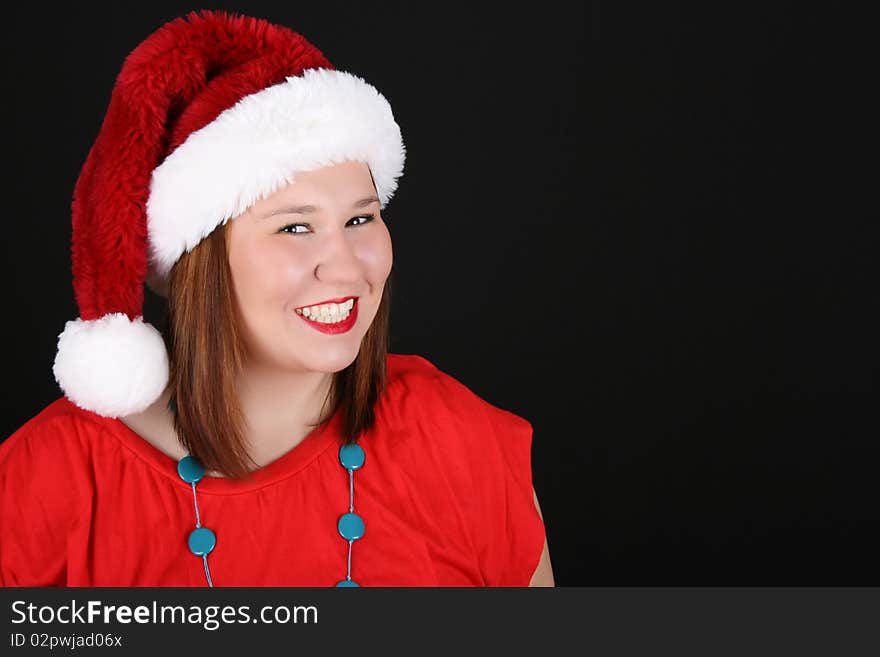 Cheerful young brunette wearing a red top and christmas hat. Cheerful young brunette wearing a red top and christmas hat