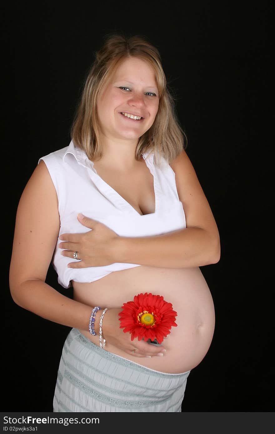 Heavily pregnant blond female against a black background. Heavily pregnant blond female against a black background