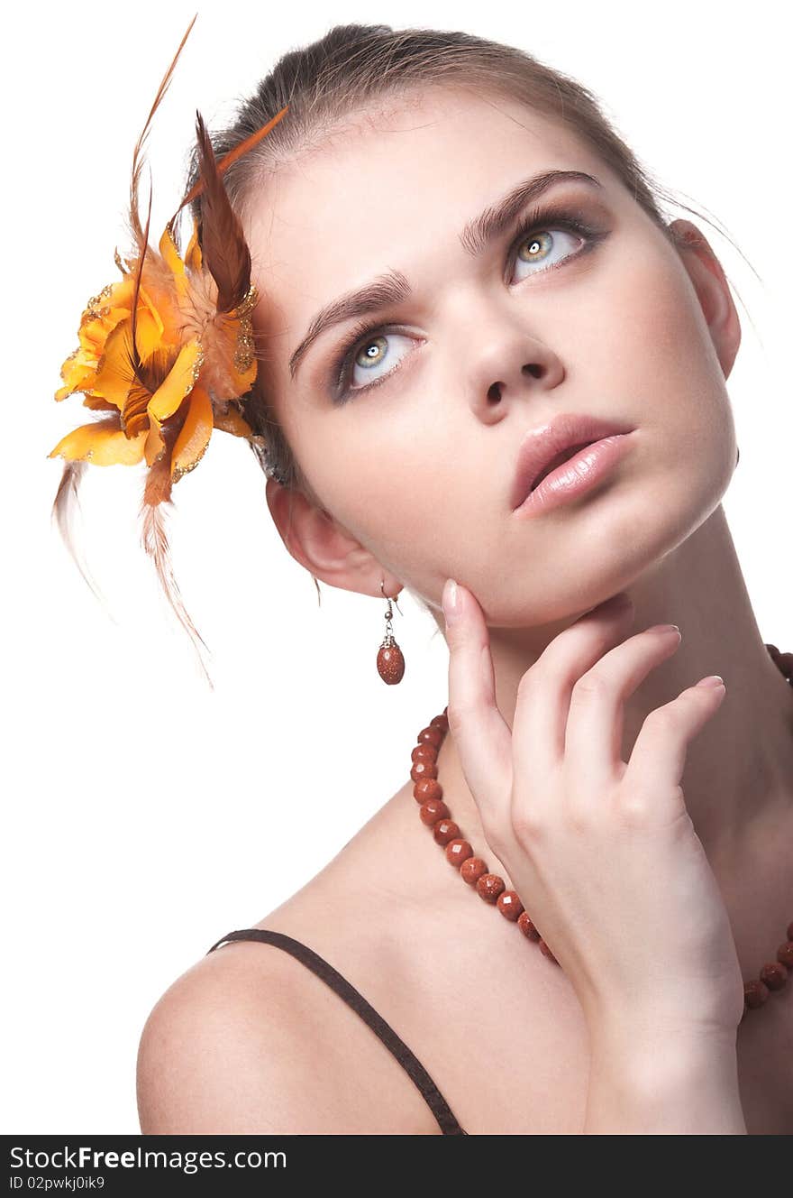 Beautiful girl with an orange flower poses on white background