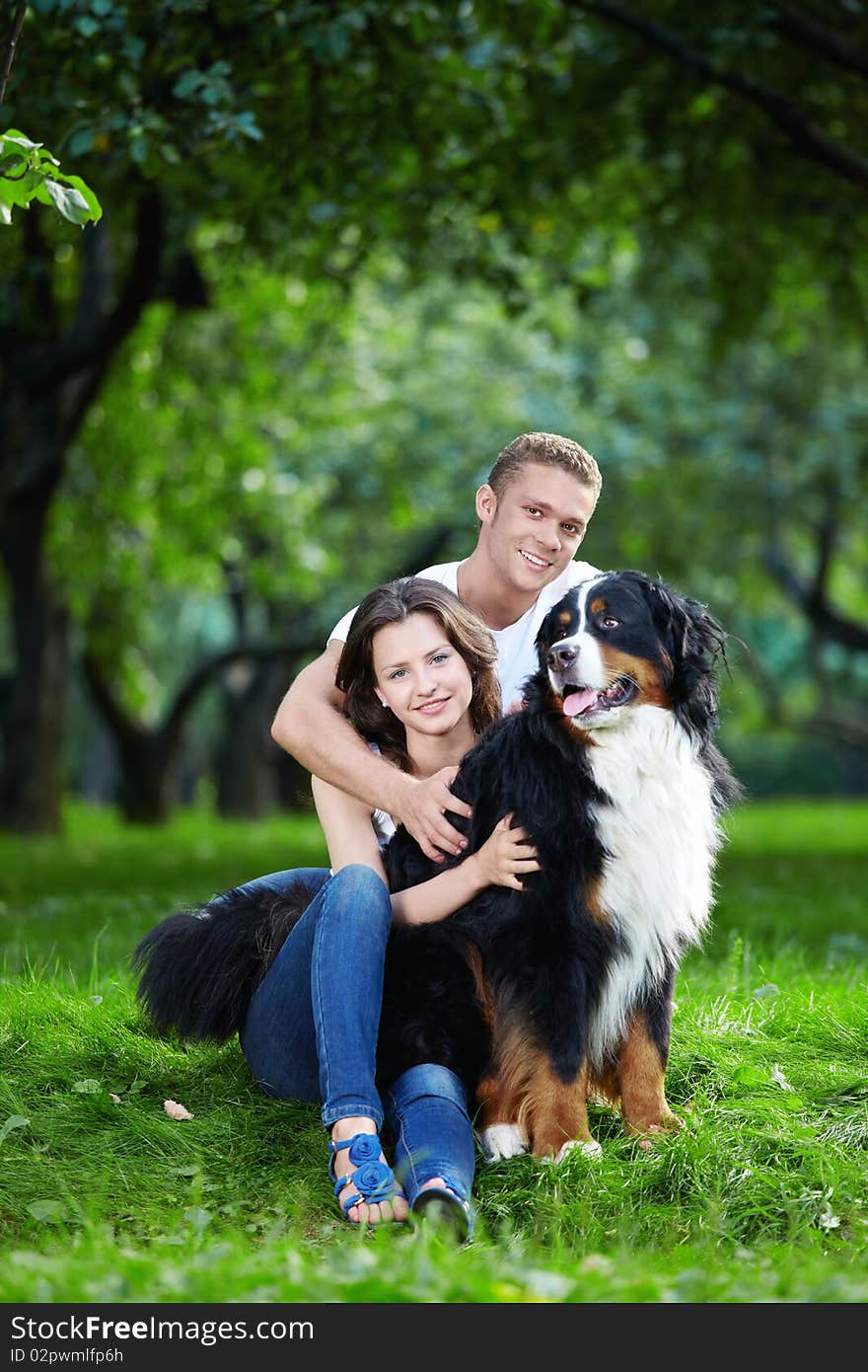 The happy couple with a dog in the park. The happy couple with a dog in the park