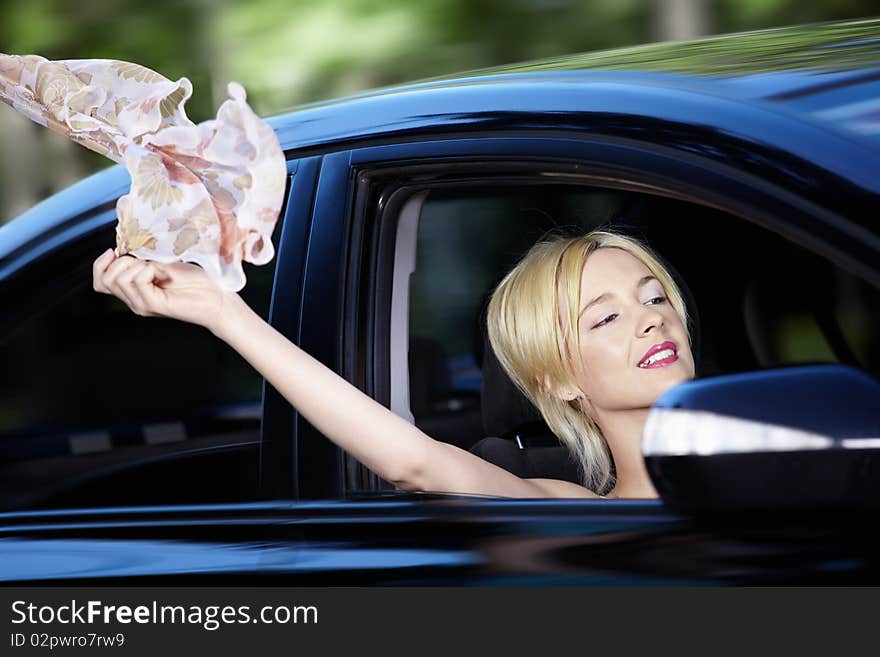 The young girl develops a scarf out of car windows. The young girl develops a scarf out of car windows