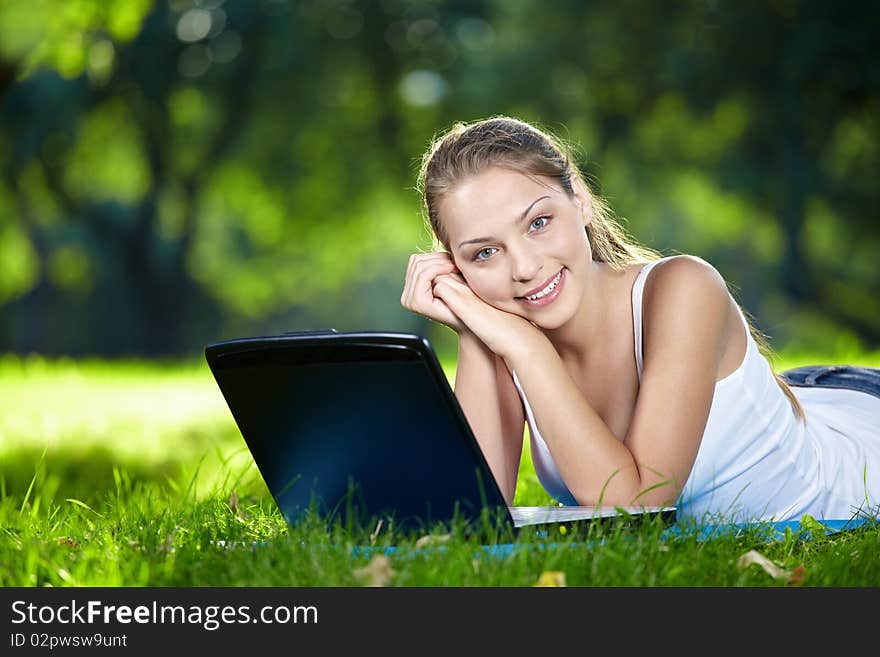 Attractive girl with a laptop in the park