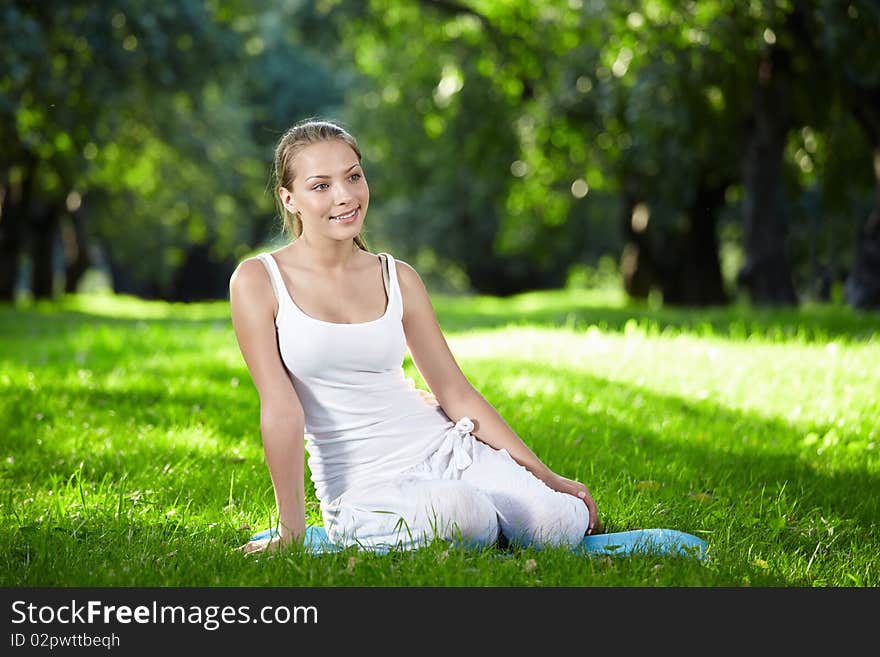 Young attractive girl sitting on the grass. Young attractive girl sitting on the grass