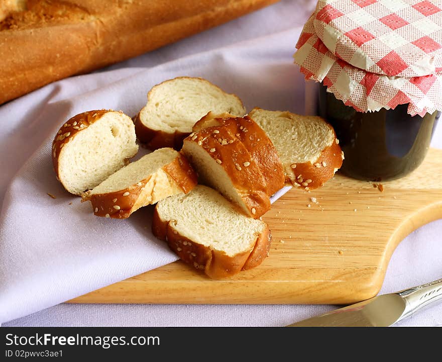 White bread with sesame and glass of jam