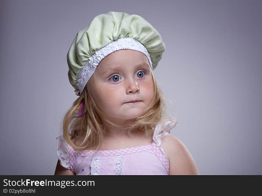 Cute girl with big blue eyes and funny green hat. Cute girl with big blue eyes and funny green hat