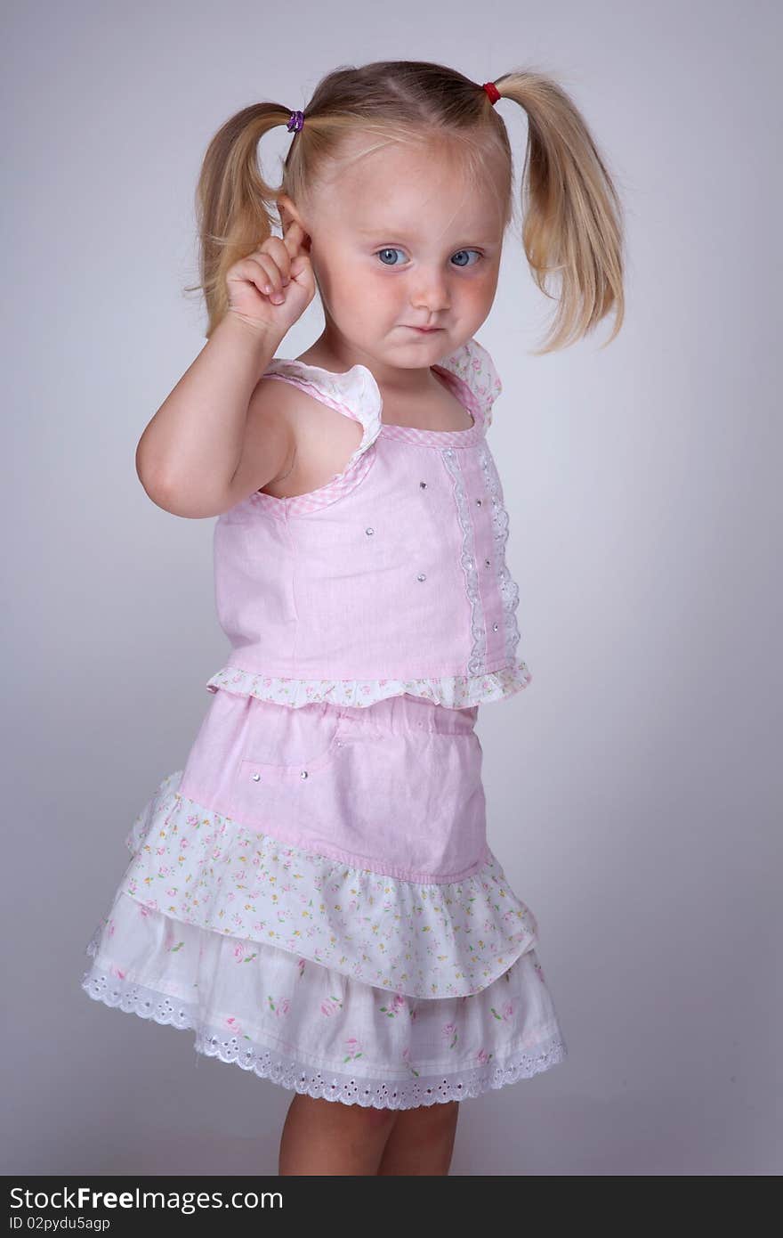 Small blonde girl with pigtails thinking. Small blonde girl with pigtails thinking