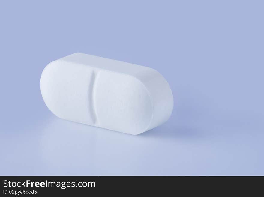 White pill on a table, close up view. White pill on a table, close up view