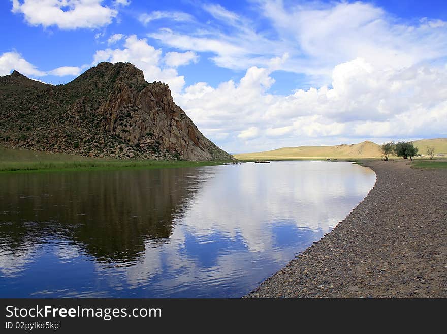 Sky and rocks reflect in  river waters. Sky and rocks reflect in  river waters