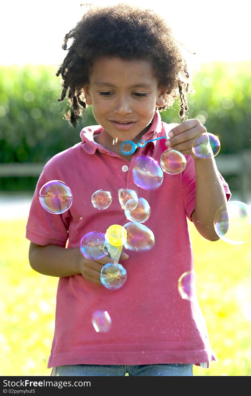 Cute little boy making soap bubbles