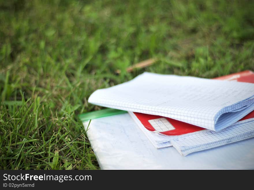 A bunch of notebooks sitting on grass. A bunch of notebooks sitting on grass