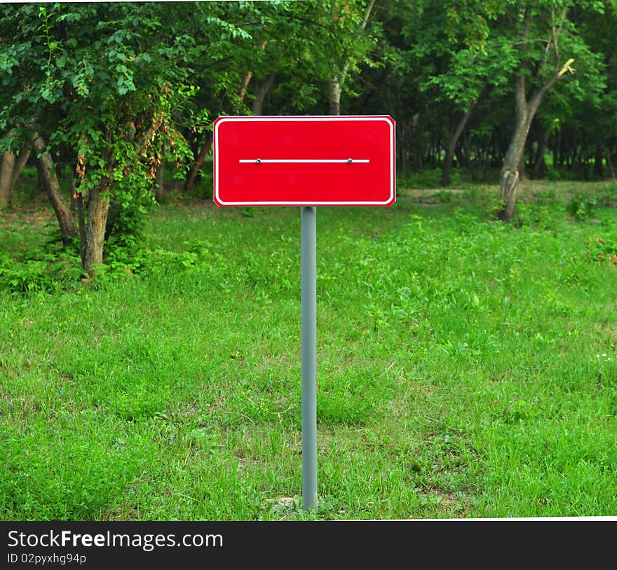 Red metal plate is established on wood glade