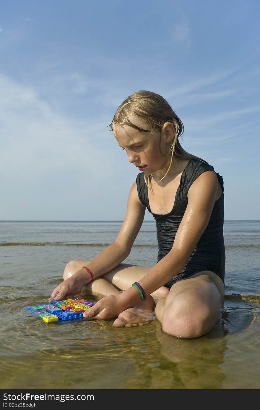 Small girl with letters on the beach. Small girl with letters on the beach.