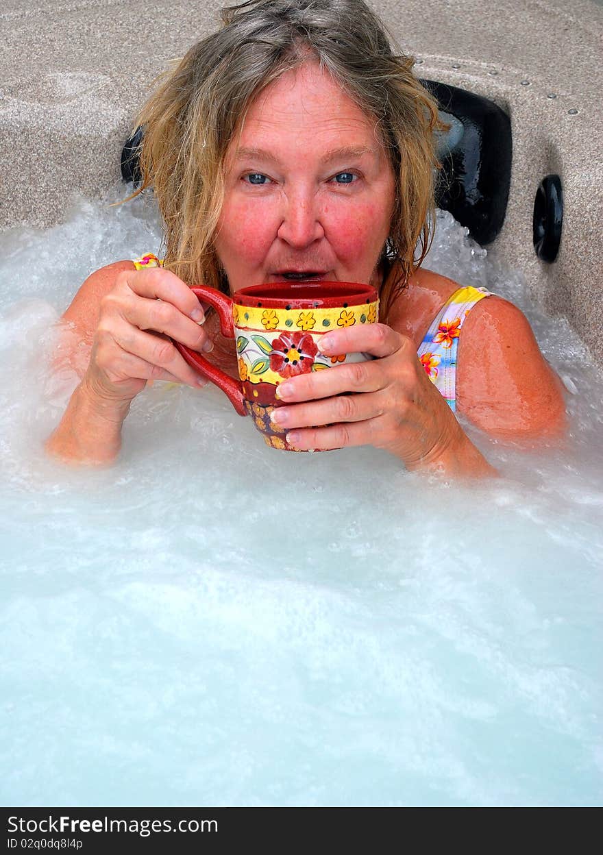 Woman having her morning coffee while relaxing in the hot tub. Woman having her morning coffee while relaxing in the hot tub.