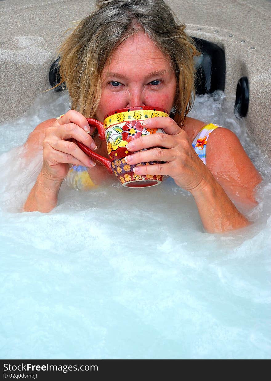 Woman having her morning coffee while relaxing in the hot tub. Woman having her morning coffee while relaxing in the hot tub.