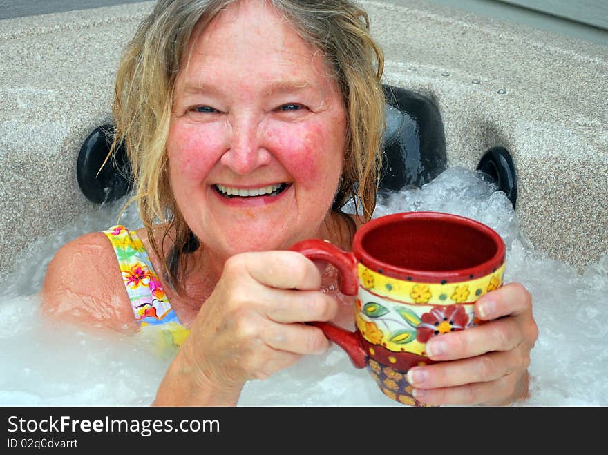 Woman having her morning coffee while relaxing in the hot tub. Woman having her morning coffee while relaxing in the hot tub.