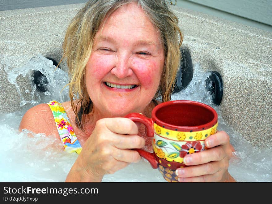 Woman having her morning coffee while relaxing in the hot tub. Woman having her morning coffee while relaxing in the hot tub.