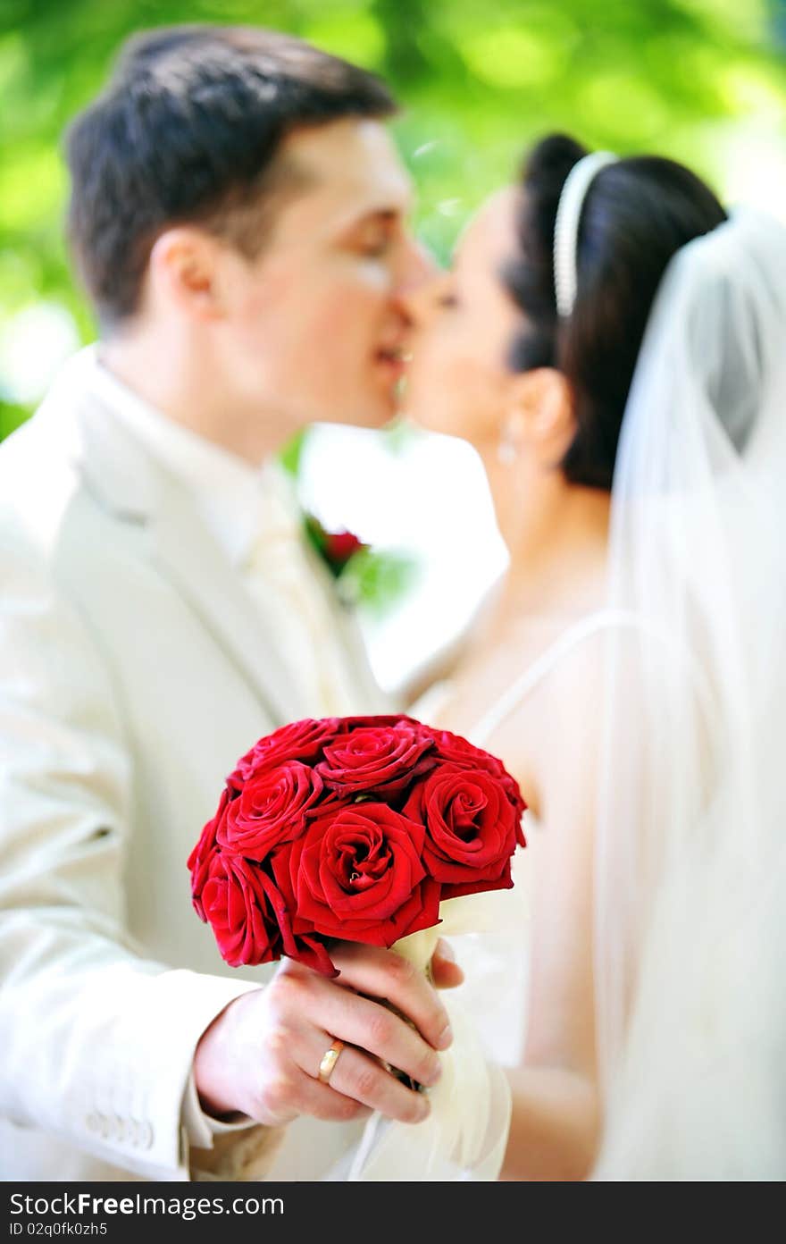 Groom and bride in white dress on background of green trees. Groom and bride in white dress on background of green trees