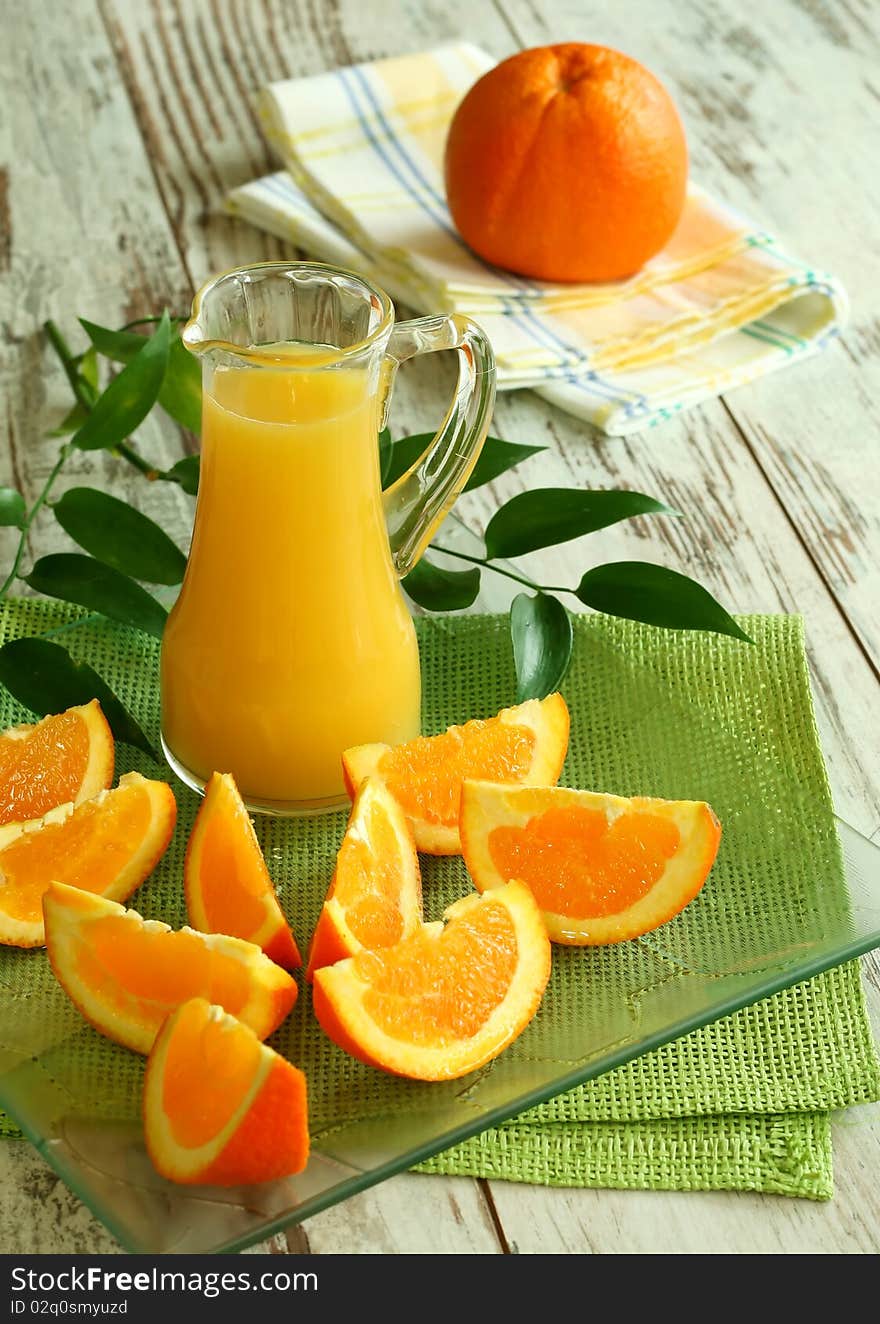 Fresh oranges and orange juice in glass on wooden boards