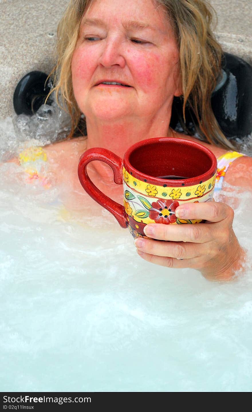 Woman having her morning coffee while relaxing in the hot tub. Woman having her morning coffee while relaxing in the hot tub.