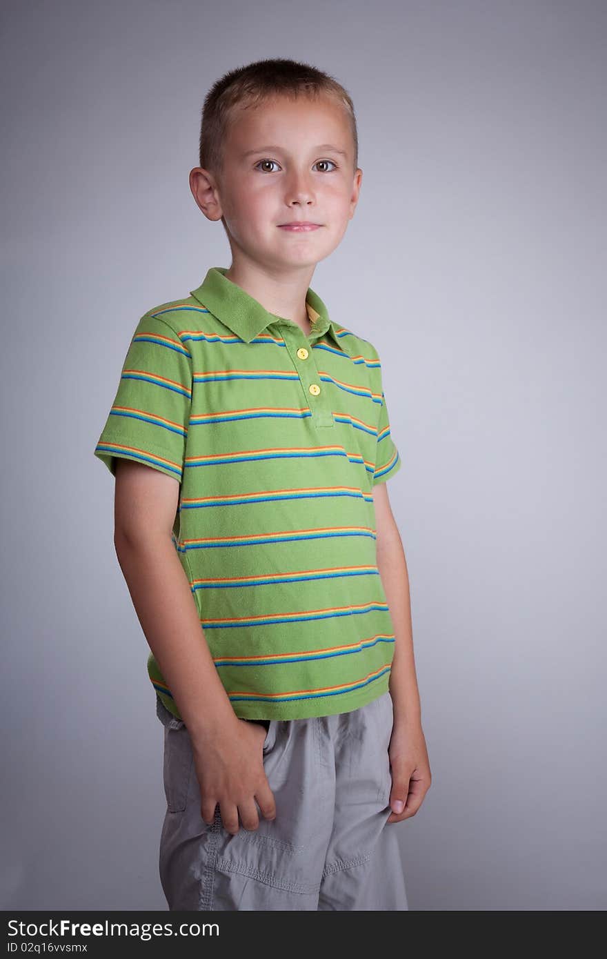 Blonde kid with gray pants and green blouse with stripes