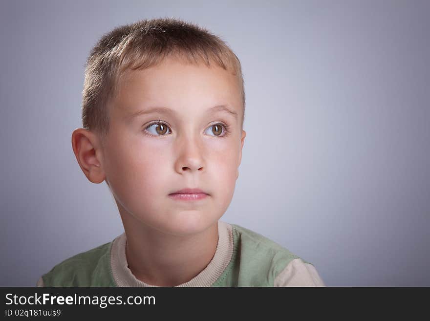 Serious young blonde boy in photo studio portrait. Serious young blonde boy in photo studio portrait