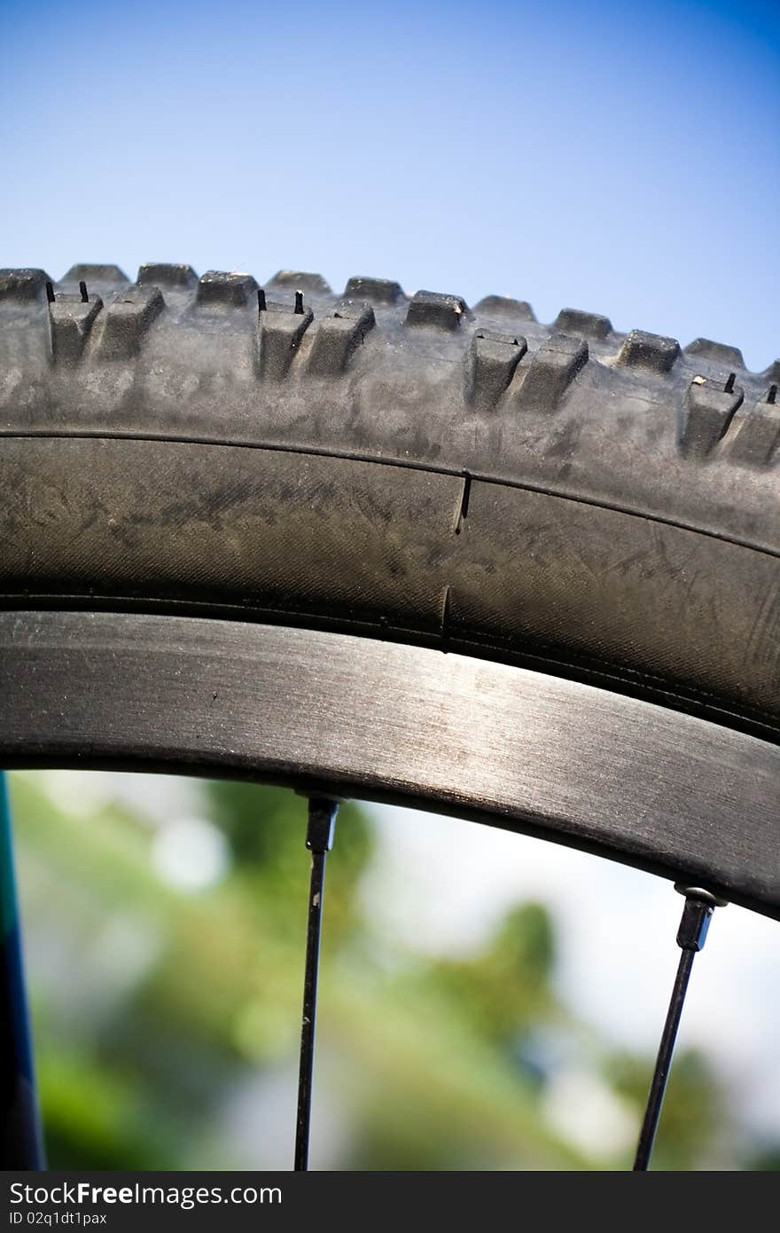 Mountain bike wheel closeup outdoors with blurred background. Mountain bike wheel closeup outdoors with blurred background