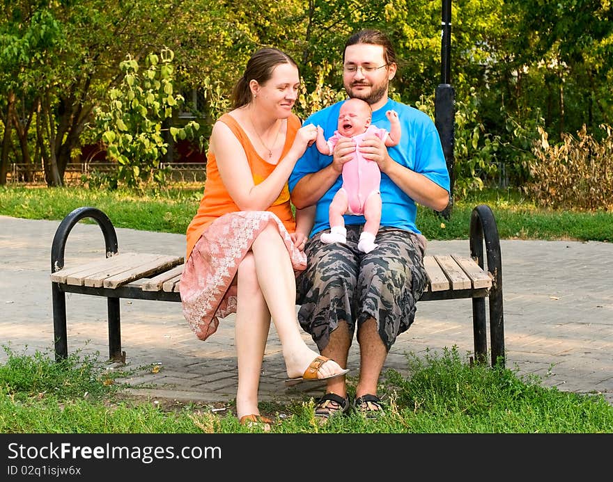 Portrait of family with bby on the bench in park. Portrait of family with bby on the bench in park