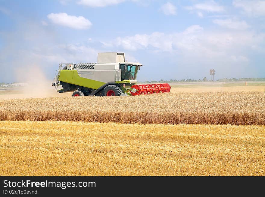 Modern combine harvester working on a wheat crop. Modern combine harvester working on a wheat crop